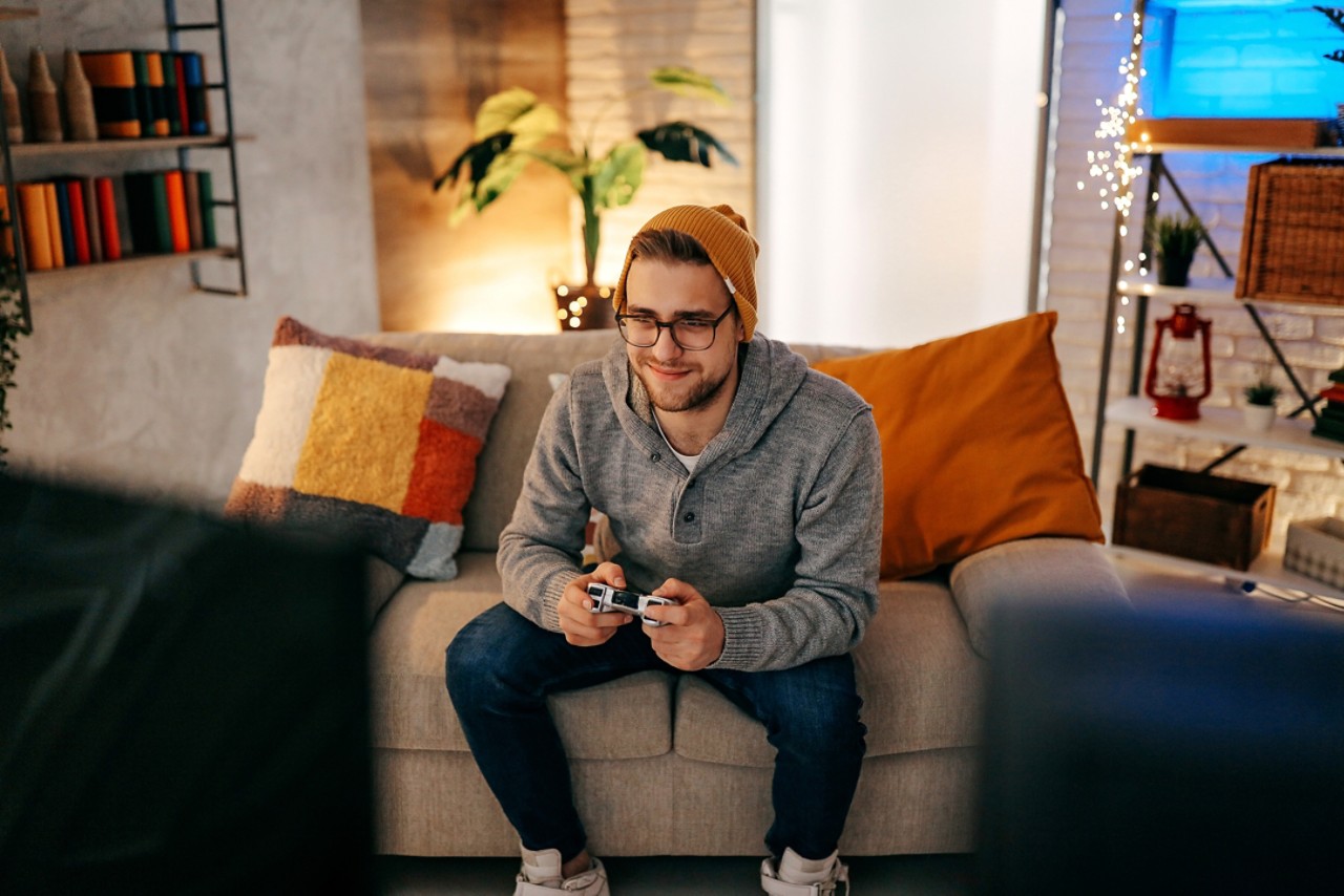 Concentrated guy playing video game with joystick