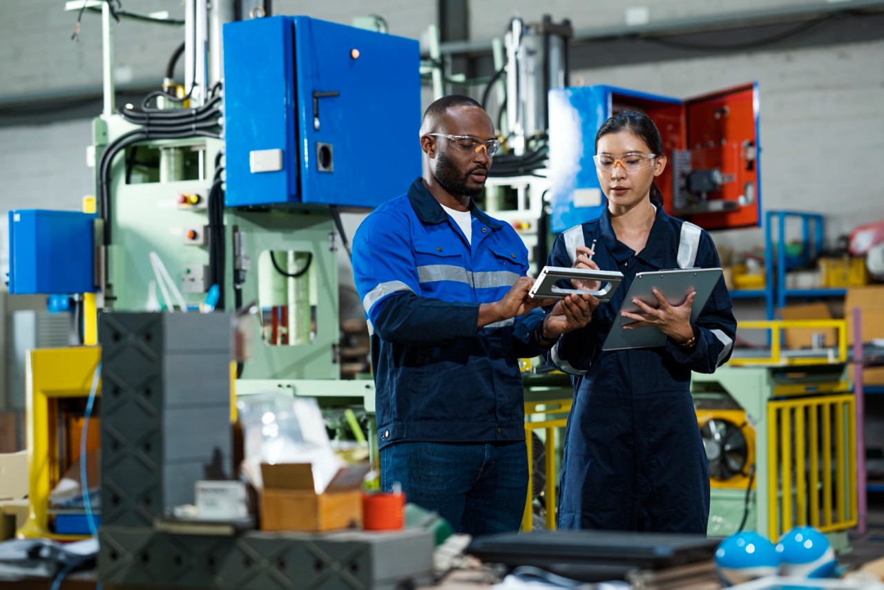 Two Mechanical Engineers in Safety Goggles Looking at a Piece of Equipment