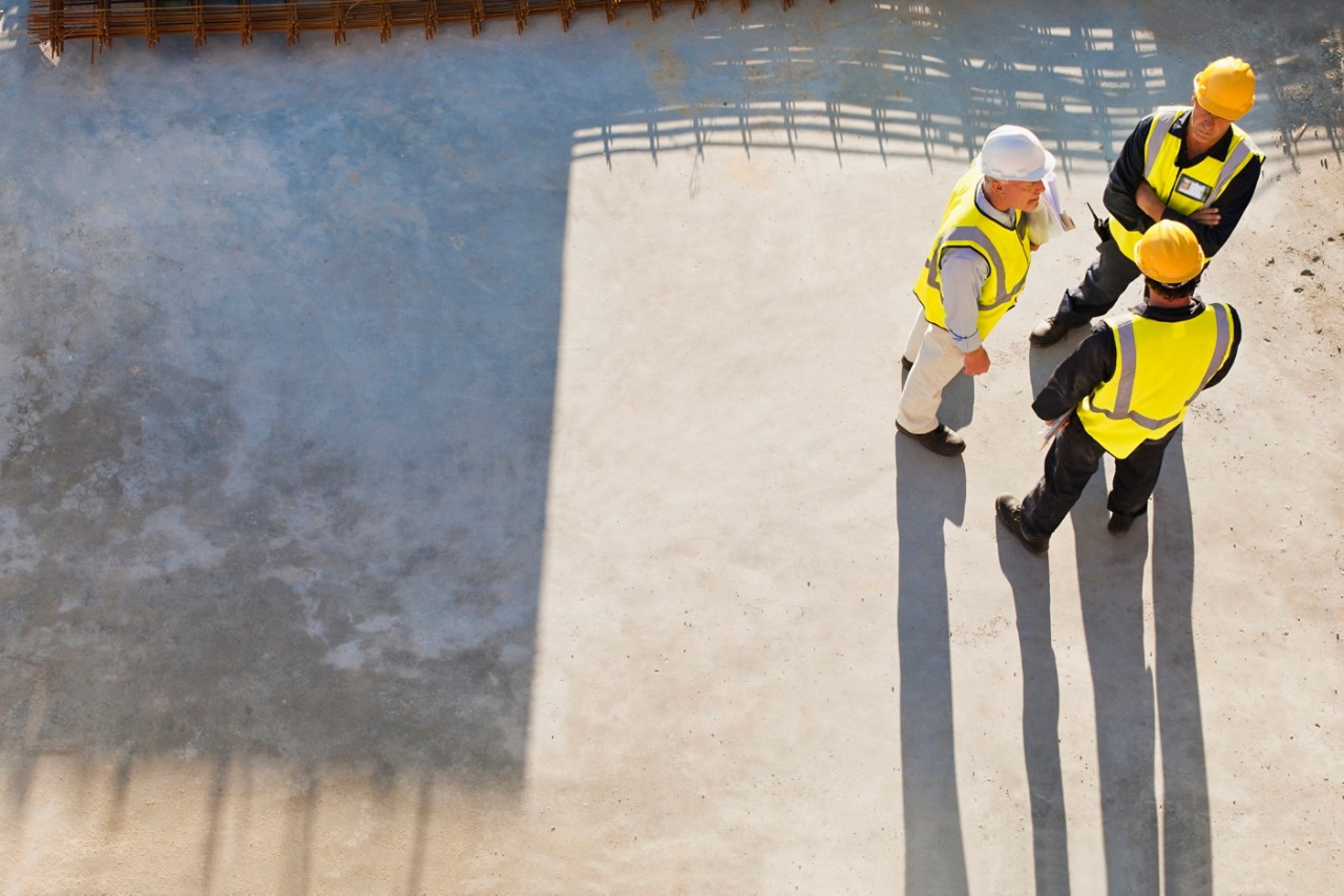 Workers casting shadows on site