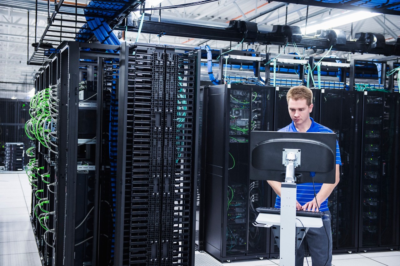 Caucasian technician using computer in server room