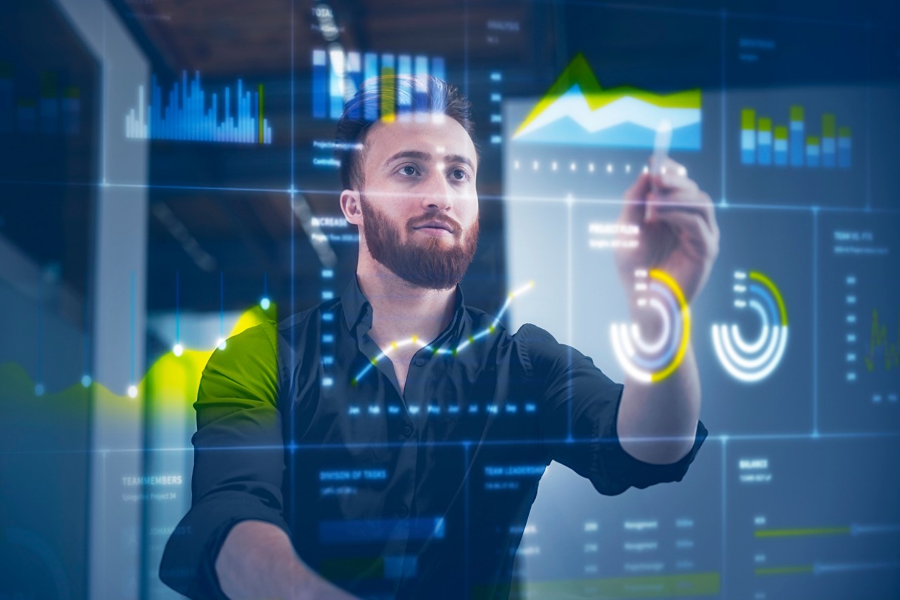 businessman reviews IIoT data on digital display in control room