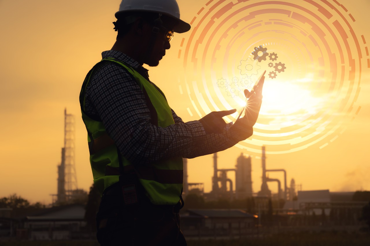 engineer with tablet refinery sunset iiot