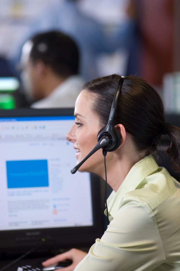 Call center representative wearing headset and speaking side view