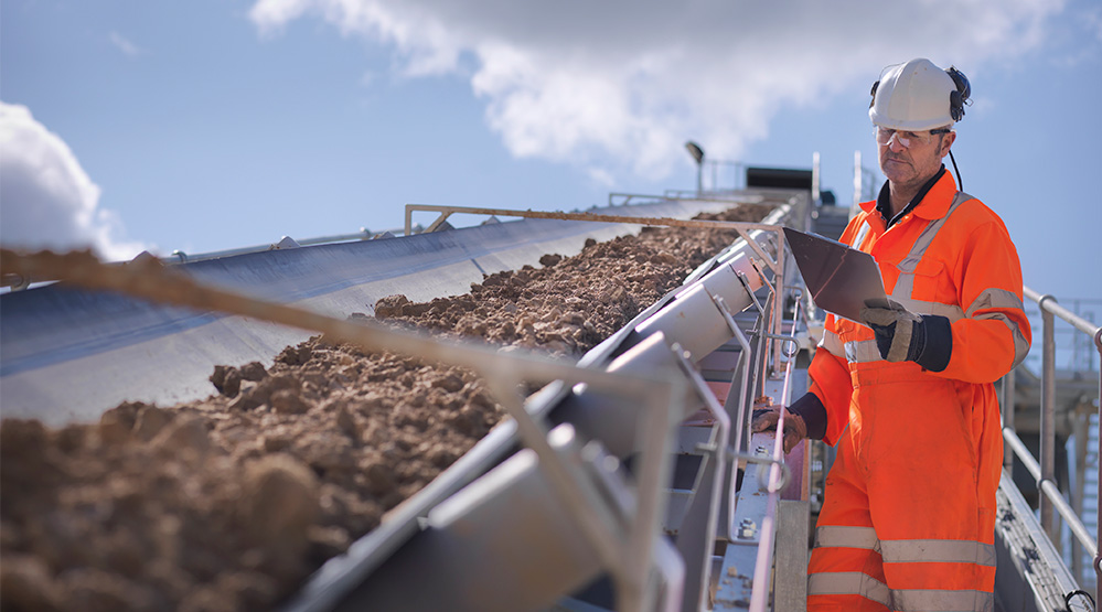 worker-inspecting-stone-screening-crushing-machine-getty-150639582