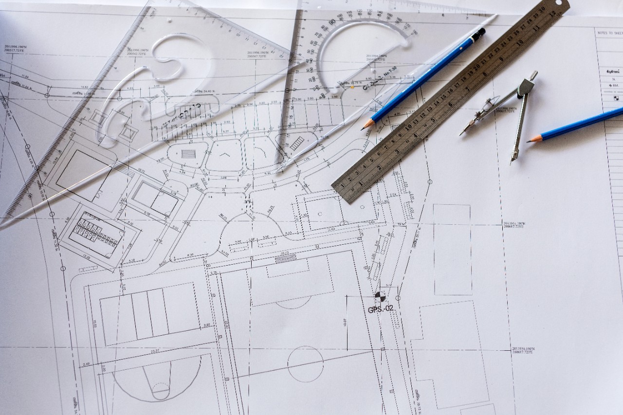"Architect engineer and head constructor working on a building site holding a blueprints at construction site."Close-up of Architect engineer drawing plan on blueprint with architect equipment