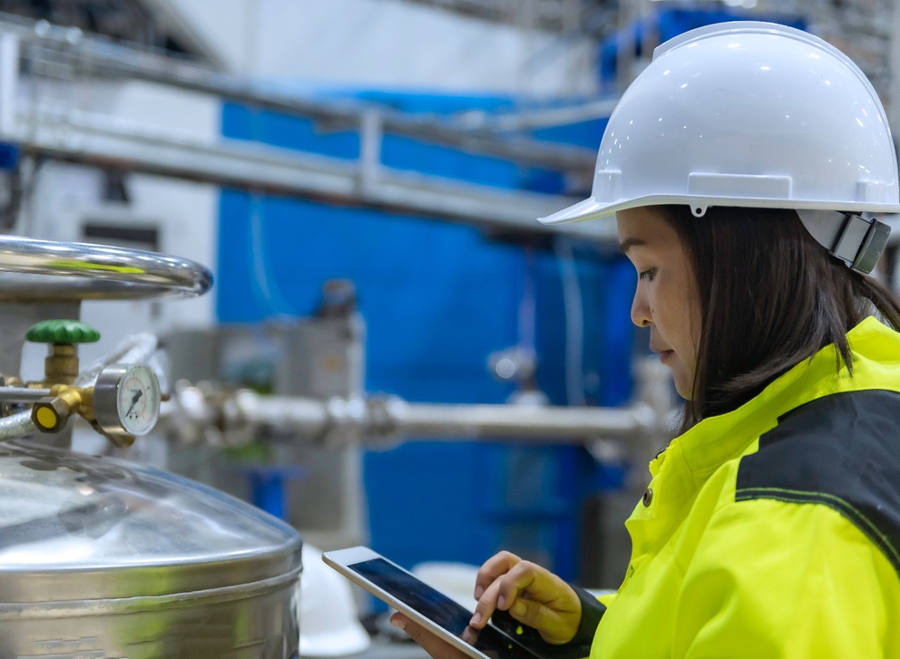 Asian engineer working at Operating hall,Thailand people wear helmet  work,He worked with diligence and patience,she checked the valve regulator at the hydrogen tank.