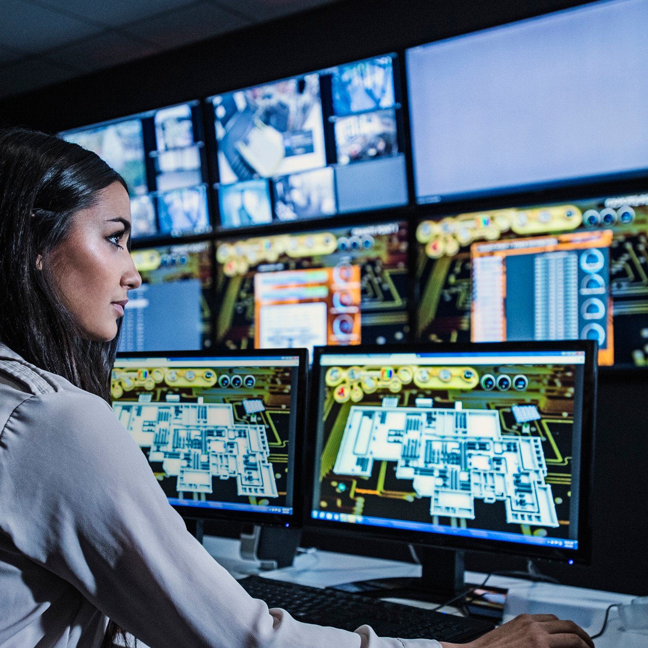 Mixed race security guard watching monitors in control room